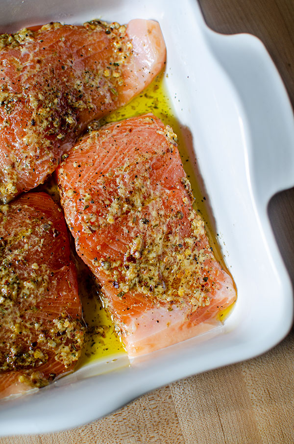Trout fillet in baking dish with marinade on top.