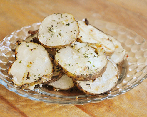 Sliced herb grilled potatoes on a plate