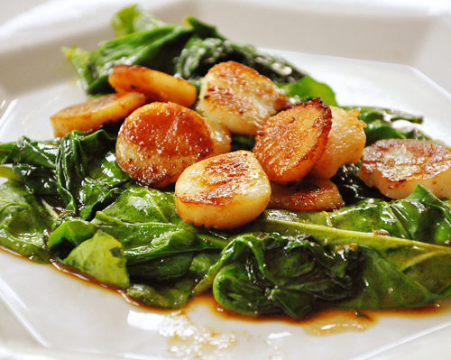 seared scallops over a bed of wilted spinach