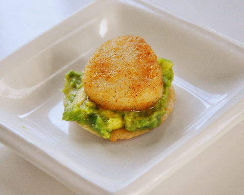 spicy seared scallops on top of avocado on a rice cracker