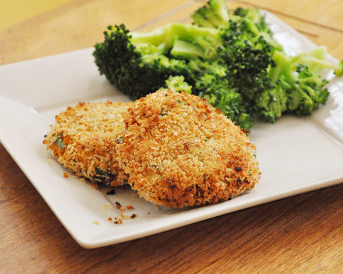 Two salmon cakes on a plate with broccoli