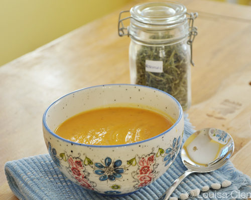 Roasted sweet potato soup in a floral board on a blue napking