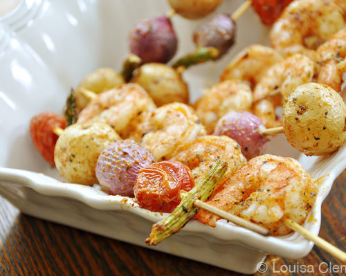 Cooked shrimp and vegetable skewers in a bowl