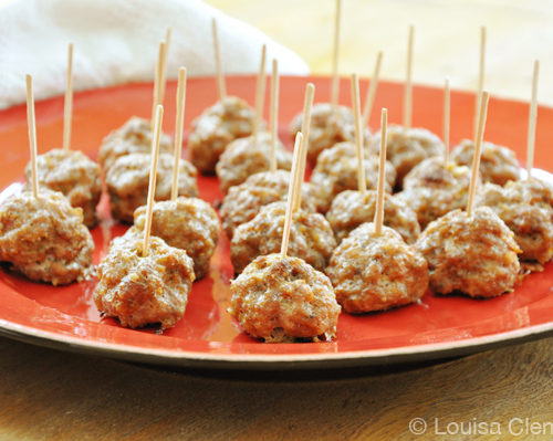A plate with appetizer meatballs on it with toothpicks in them