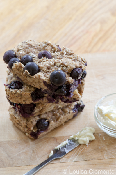 A stack of blueberry breakfast bars with a bowl of cream cheese