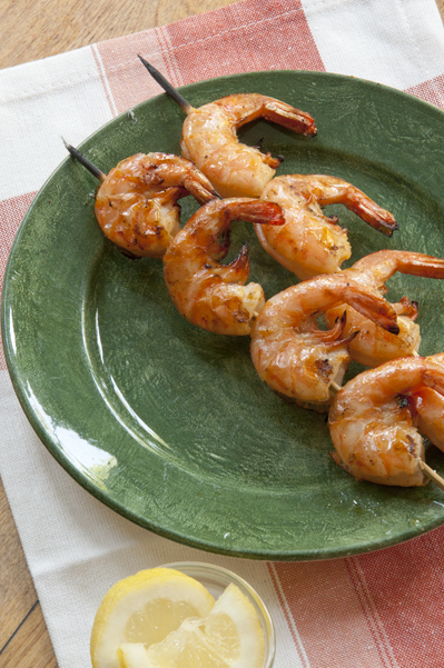 Grilled shrimp skewers on a green plate