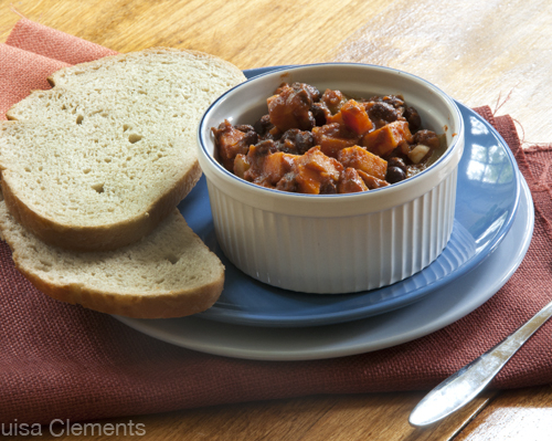 A bowl of vegetarian chili with two slices of sourdough bread