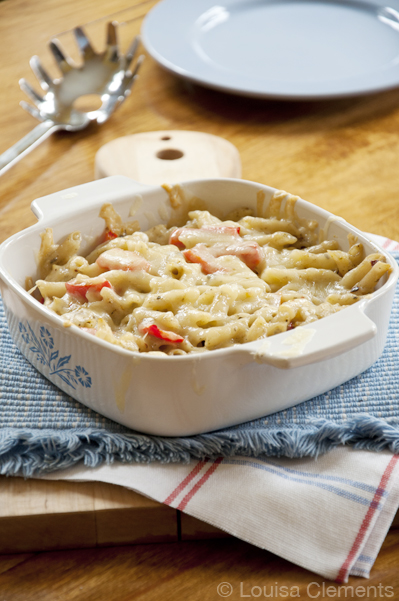 A casserole dish with cheesy baked pesto pasta