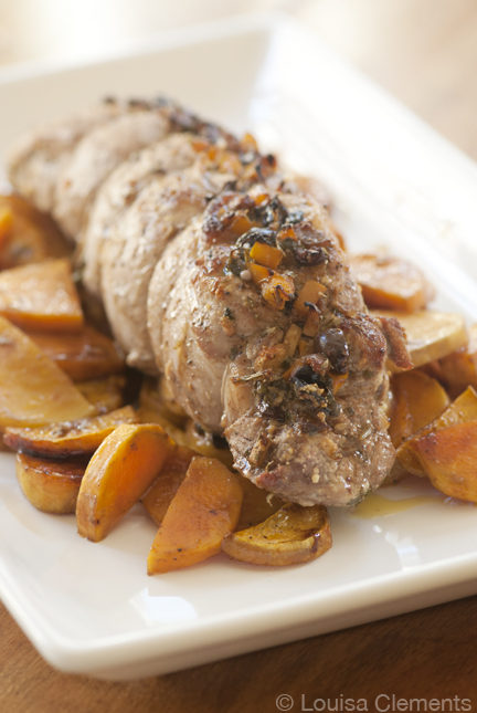 stuffed pork tenderloin on a bed of sliced sweet potatoes