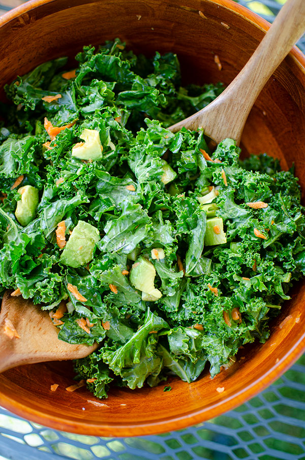 Kale avocado salad in a wooden bowl.