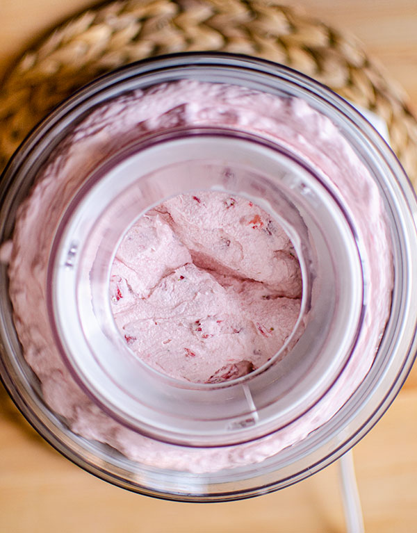 Strawberry ice cream being churned in an ice cream machine.