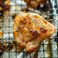 Close up of crispy perfectly roasted chicken thighs on a baking sheet..