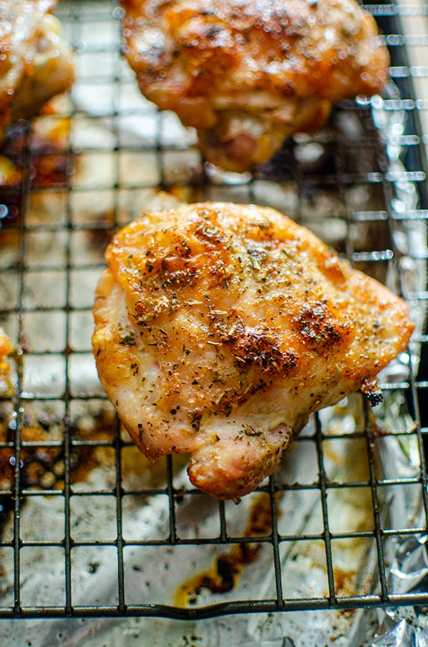 Close up of crispy perfectly roasted chicken thighs on a baking sheet..