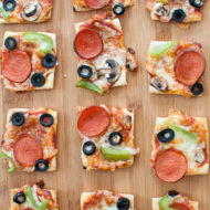 puff pastry pizza bites cut into squares on a cutting board