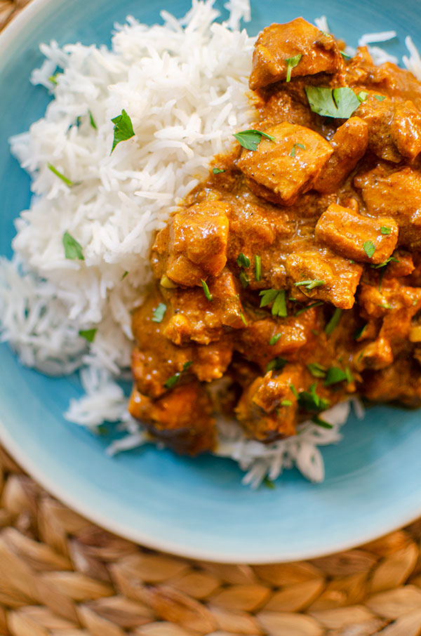 Closeup of slow cooker butter chicken with rice and cilantro