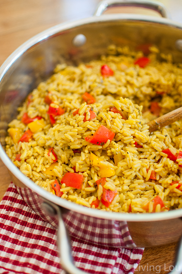 Bell pepper rice in a stainless steel saute pan with a wooden spoon