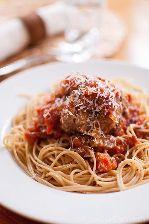 Slow cooker meatballs in tomato sauce serve on pasta