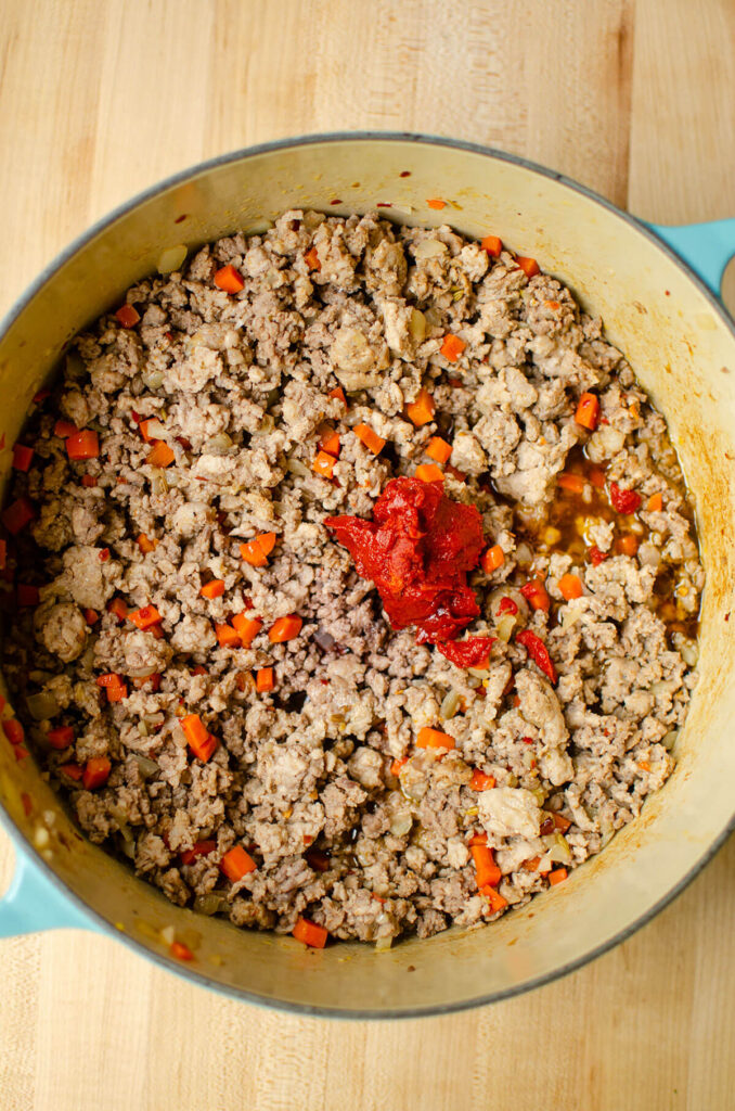 Cooked ground meat, onions and carrot with a blob of tomato pate on top.