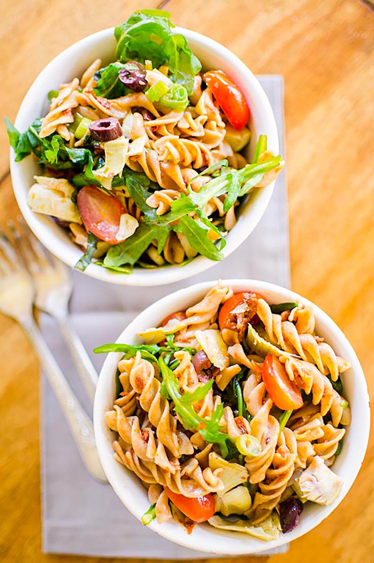 Two servings of pasta salad in white bowls