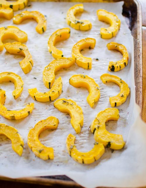 A sheetpan of sliced, roasted delicata squash.