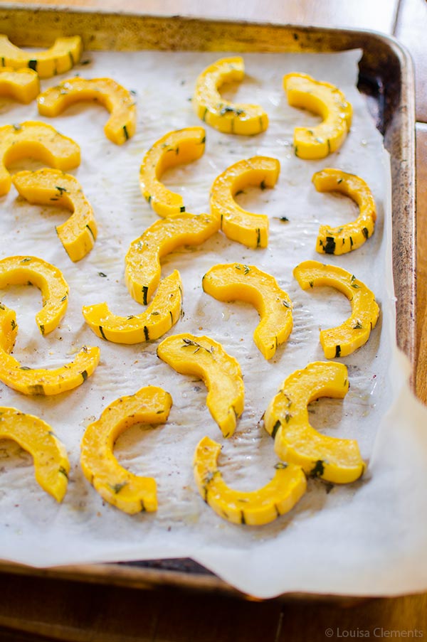 A sheetpan of sliced, roasted delicata squash.