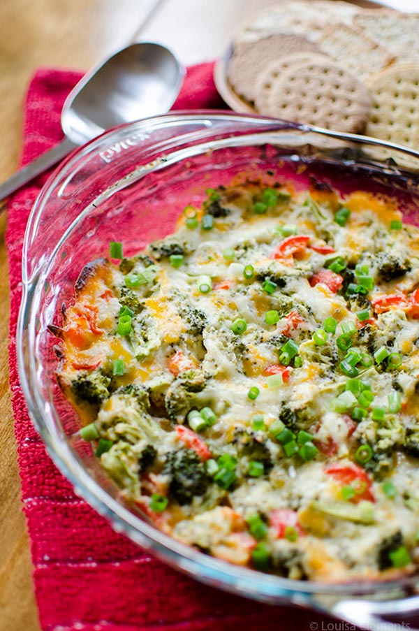 The perfect appetizer for entertaining or for game day, this cheesy broccoli dip is a healthier vegetarian option loaded with broccoli and red peppers. | livinglou.com