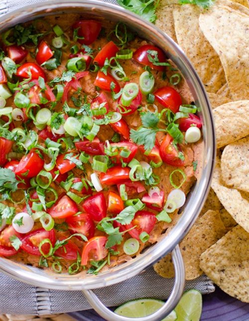 A cheesy refried bean dip with tomato, green onion and cilantro. | livinglou.com