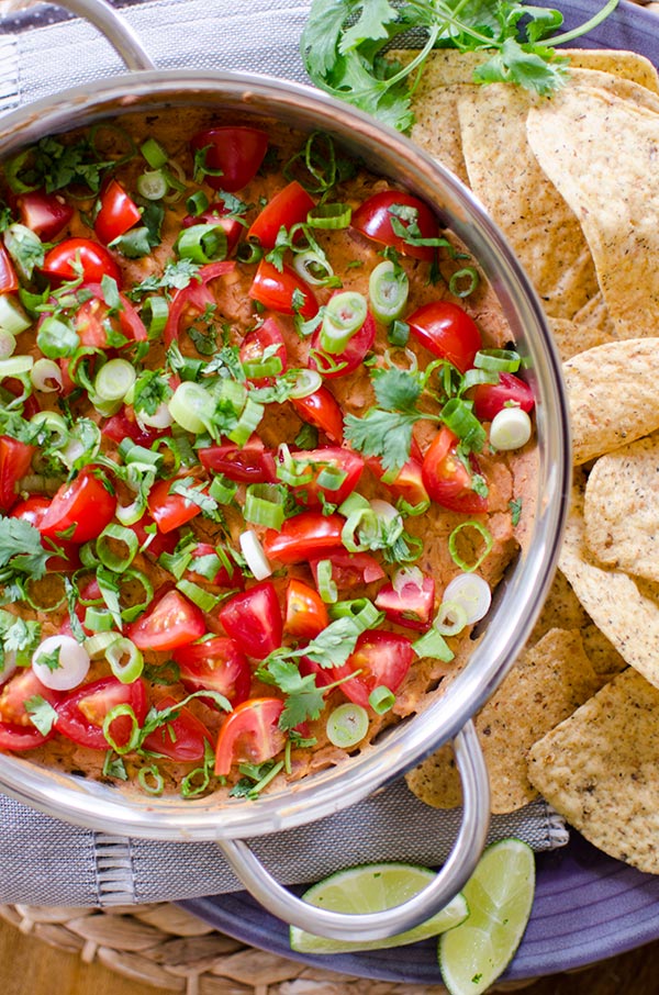 A cheesy refried bean dip with tomato, green onion and cilantro. | livinglou.com