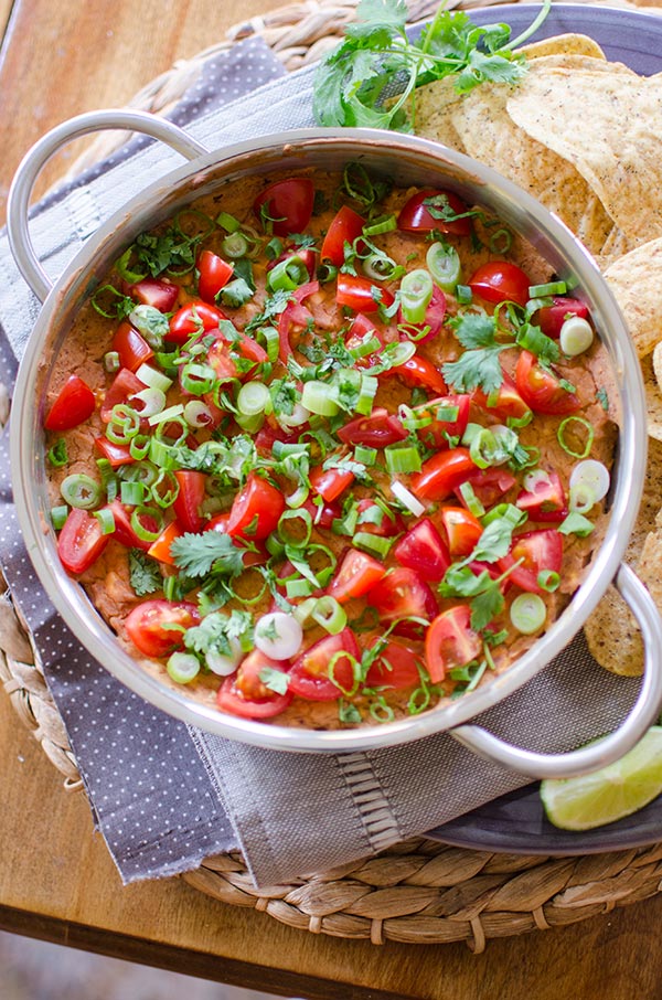 A cheesy refried bean dip with tomato, green onion and cilantro. | livinglou.com