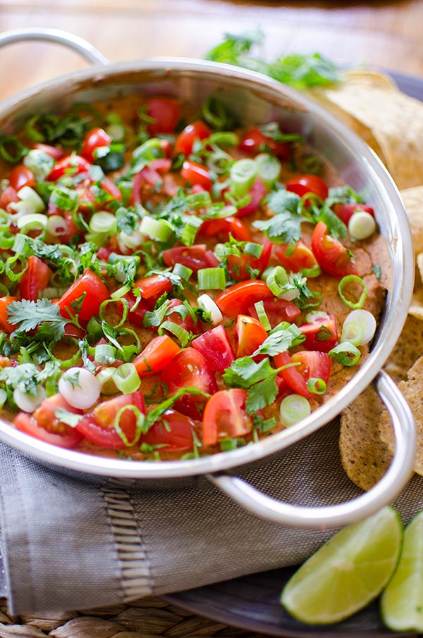 A cheesy refried bean dip with tomato, green onion and cilantro. | livinglou.com