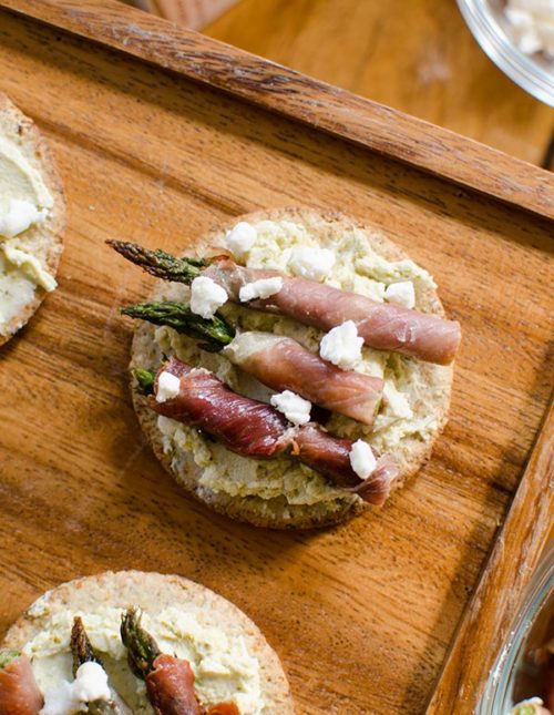 Prosciutto wrapped asparagus with pesto goat cheese on crackers is the perfect holiday appetizer for a cocktail party. | Livinglou.com