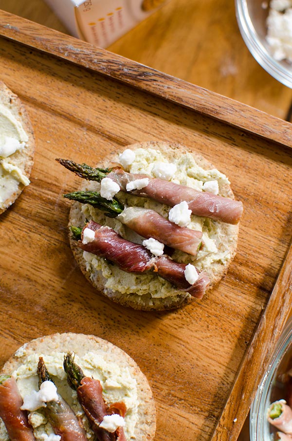 Prosciutto wrapped asparagus with pesto goat cheese on crackers is the perfect holiday appetizer for a cocktail party. | Livinglou.com