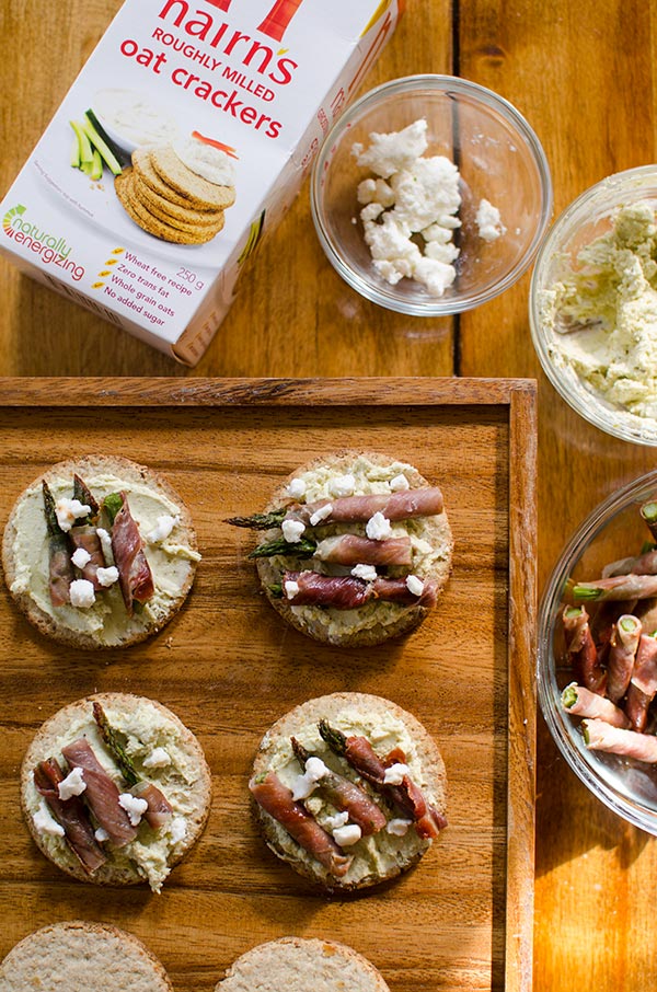 Prosciutto wrapped asparagus with pesto goat cheese on crackers is the perfect holiday appetizer for a cocktail party. | Livinglou.com