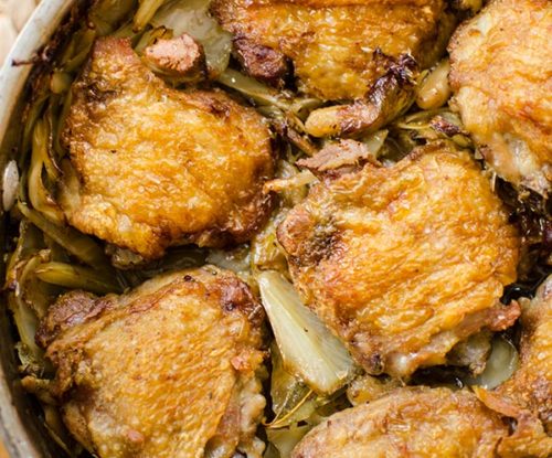 Crispy braised chicken thighs in a pot with mushrooms, white beans, cabbage and bacon