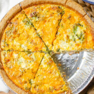 Closeup of broccoli bacon quiche cut into slices with a slice missing.