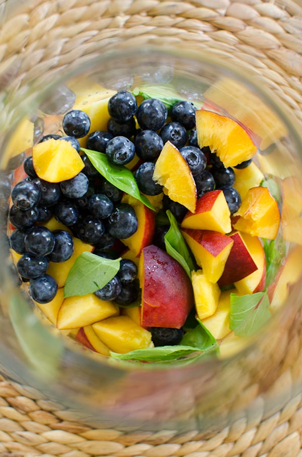 Peach sangria with blueberries, basil and rose for a crowd for a refreshing summer cocktail. | livinglou.com