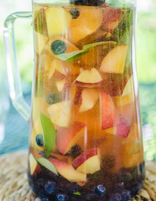 Peach sangria with blueberries, basil and rose for a crowd for a refreshing summer cocktail. | livinglou.com