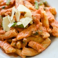 Pasta with salmon and asparagus in a creamy rose sauce in a white bowl