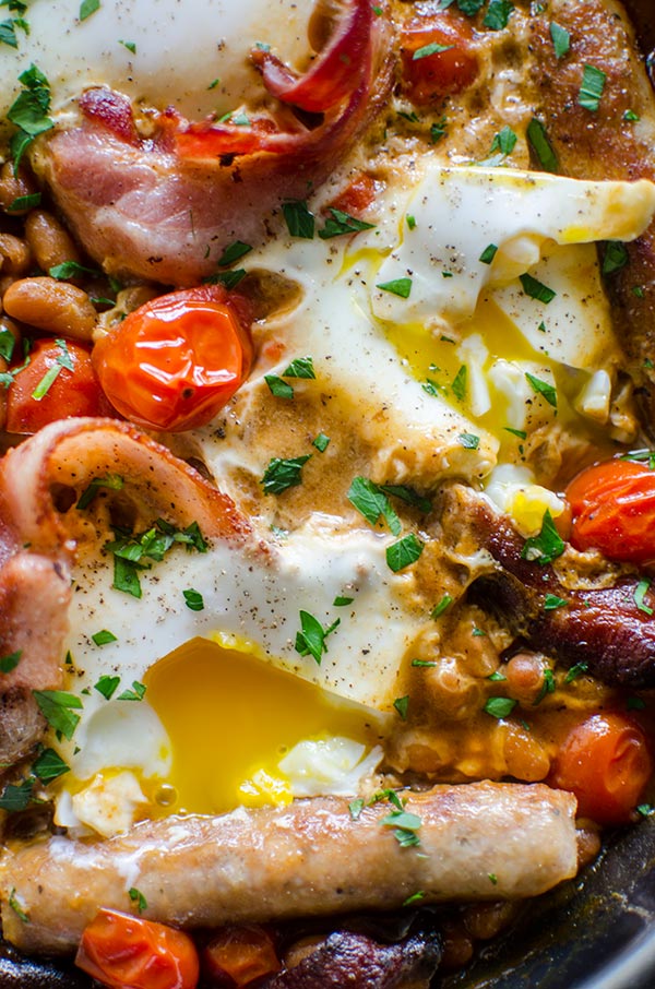 Make a full English breakfast in one pan with cherry tomatoes, bacon, sausages, baked beans and eggs. | livinglou.com
