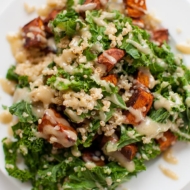 Sweet potato, kale and quinoa come together with a creamy tahini dressing on a plate