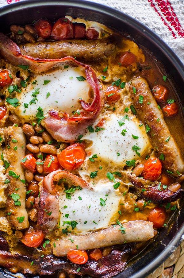 Make a full English breakfast in one pan with cherry tomatoes, bacon, sausages, baked beans and eggs. | livinglou.com