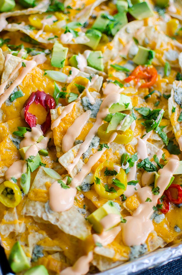 Enjoy all the flavours of Buffalo chicken in this nacho recipe for spicy Buffalo nachos with tons of cheddar and blue cheese, hot peppers and a Buffalo sour cream. | livinglou.com