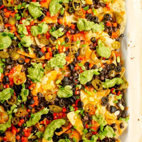 Closeup of vegetarian nachos on a baking sheet.