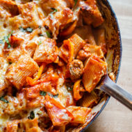 A scoop being taken out of cheesy sausage and pepper pasta