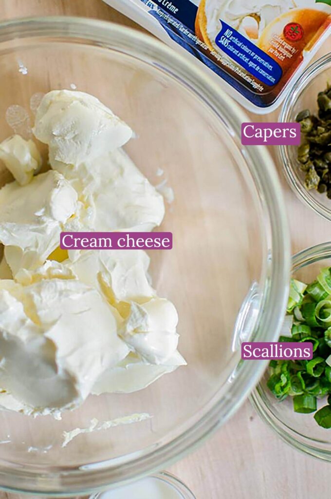 Ingredients for scallion cream cheese on a wooden board.