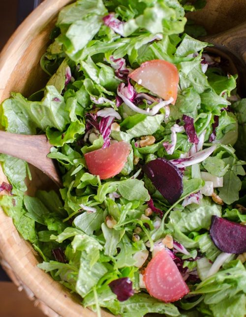 Salad with roasted beets and raddicchio and feta in a wooden bowl.