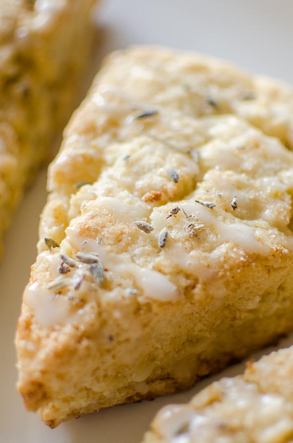 Light and fluffy homemade lemon scones with a lemon glaze and sprinkled with lavender. | livinglou.com