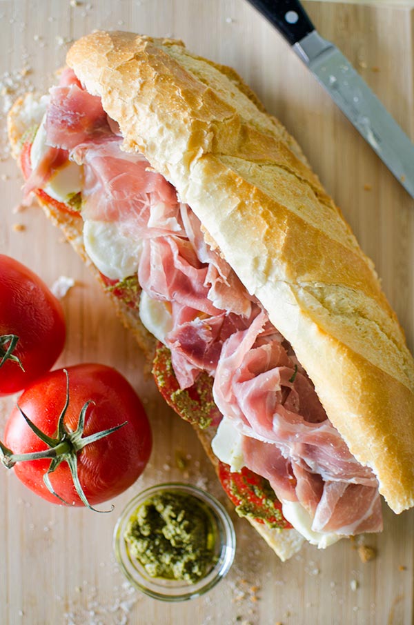 Prosciutto mozzarella and pesto marinated tomato sandwich. | livinglou.com