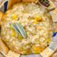 Butternut squash risotto in a colourful bowl with a fresh sage garnish.