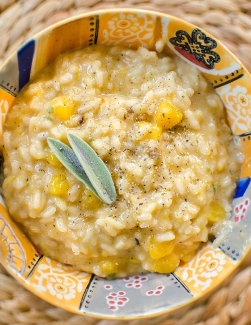 Butternut squash risotto in a colourful bowl with a fresh sage garnish.